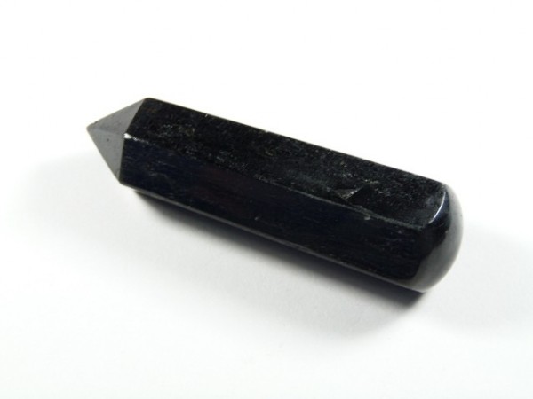 Czarny turmalin różdżka obelisk. Czarny, błyszczący kryształ o wydłużonym, szlifowanym kształcie na białym tle.