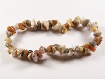 Bransoletka z nieregularnych, kolorowych kamieni na białym tle.