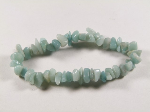 Bransoletka z nieregularnych, jasnoniebieskich kamieni na białym tle.