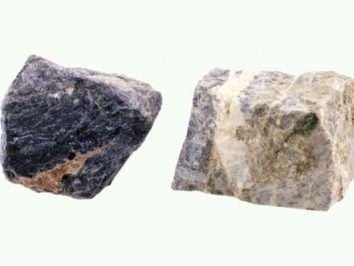 Dwa surowe kawałki minerałów o różnych kolorach na jasnym tle.