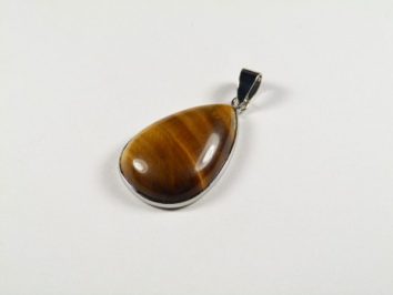 Wisiorek w kształcie łezki z kamieniem tygrysie oko na białym tle.