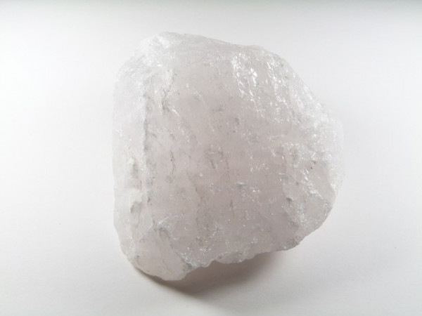 Biały kryształowy kamień kwarcu leży na białym tle.