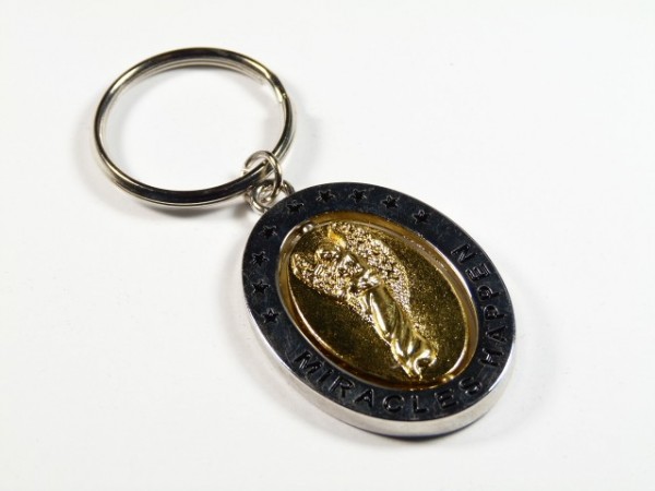 Brelok z napisem "Miracles Happen" i złotą postacią anioła na środku.