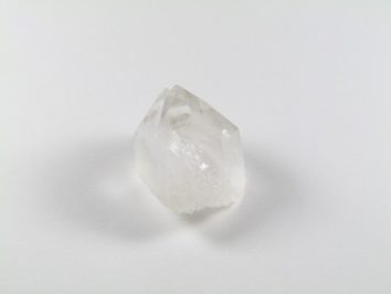 Przezroczysty kryształ kwarcu na białym tle.