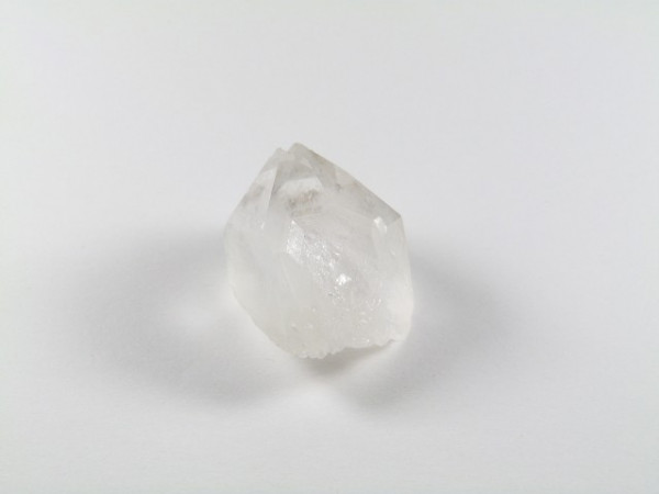 Przezroczysty kryształ kwarcu na białym tle.