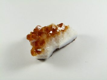 Pomarańczowy kryształ cytrynu na białym tle.