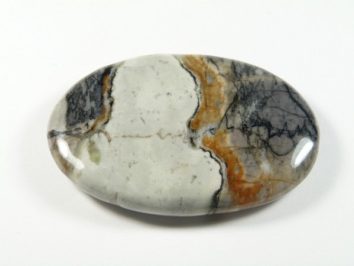 Jaspis Picasso - kamień gładzony, polerowany, szlifowany. Owalny, wypolerowany kamień z szarymi, czarnymi i pomarańczowymi wzorami na białym tle.