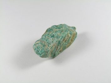 Amazonit - kamień naturalny, surowy, nieszlifowany. Zielony minerał amazonit na białym tle.