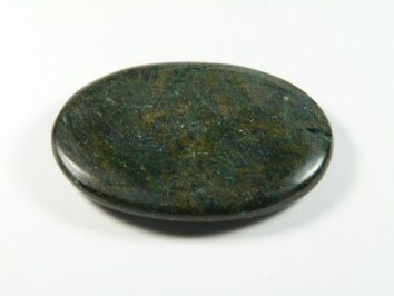 Gładki, owalny zielony kamień leży na białym tle.