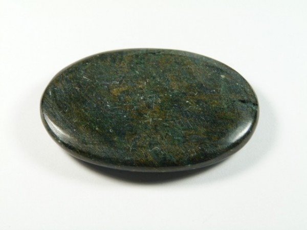 Gładki, owalny zielony kamień leży na białym tle.