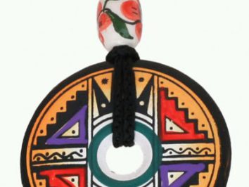 Okrągły, kolorowy wisior z wzorami geometrycznymi na czarnym sznurku z ozdobnym koralikiem.