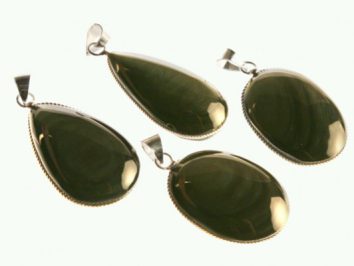 Cztery zielone wisiorki z połyskującym kamieniem, oprawione w metal.