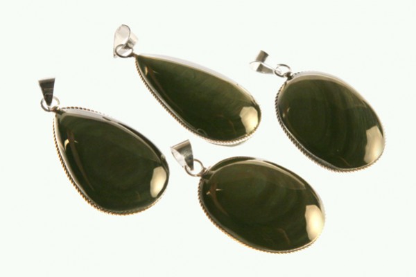 Cztery zielone wisiorki z połyskującym kamieniem, oprawione w metal.