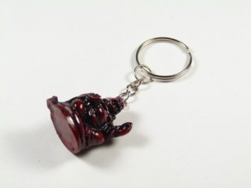 Breloczek z figurką siedzącego Buddy na białym tle.