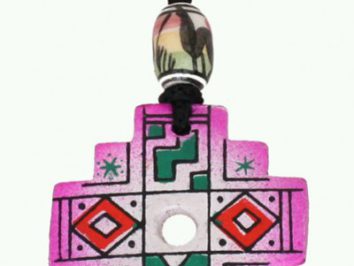 Różowy naszyjnik z krzyżowym wisiorkiem ozdobionym geometrycznym wzorem i koralikiem.