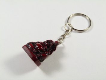 Breloczek z figurką Buddy w ciemnoczerwonym kolorze na białym tle.