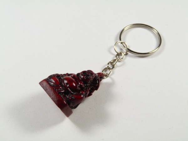 Breloczek z figurką Buddy w ciemnoczerwonym kolorze na białym tle.