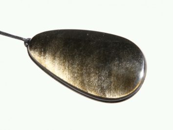 Czarny, owalny wisiorek z połyskiem na czarnym sznurku, na jasnym tle.