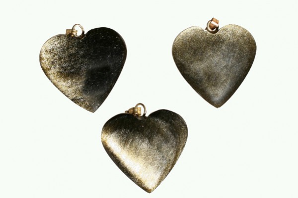 Trzy metalowe zawieszki w kształcie serca na jasnym tle.