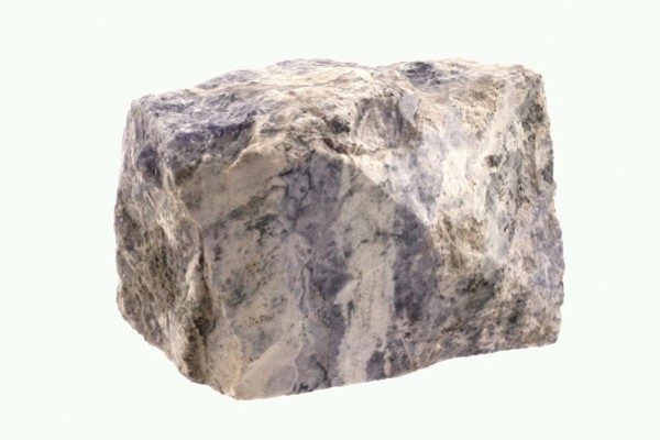 Szary, nieregularny kamień o chropowatej powierzchni na jasnym tle.