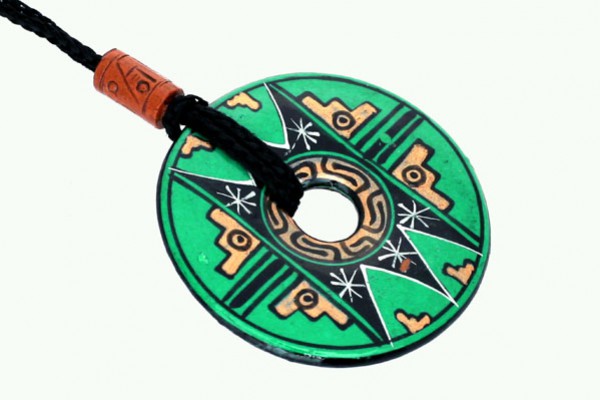 Zielony, okrągły wisiorek z etnicznym wzorem, zawieszony na czarnym sznurku.