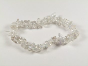 Bransoletka z przezroczystych, nieregularnych kamieni na białym tle.