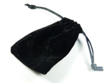 Czarny welurowy woreczek ściągnięty sznurkiem, leży na białym tle.
