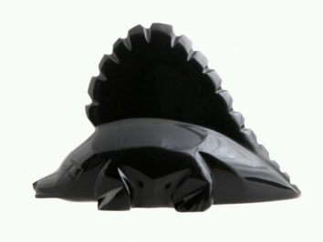 Czarna figurka dinozaura z dużym grzebieniem na grzbiecie, widok z boku.