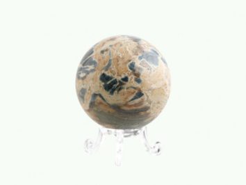 Kula z marmuru w beżowo-czarnych barwach na przezroczystej podstawce.