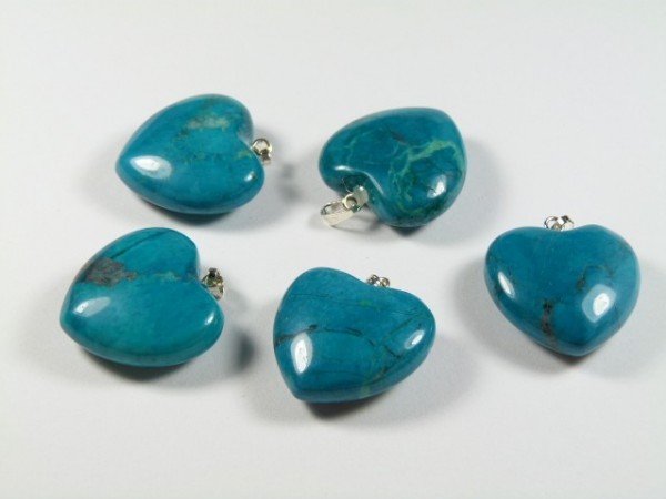 Serce/ serduszko howlit chryzokola gładzony 2,5 cm. Pięć turkusowych zawieszek w kształcie serca leży na białym tle.