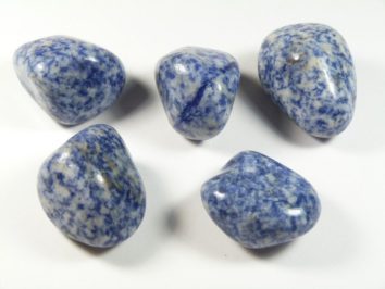 Pięć wypolerowanych, niebiesko-białych kamieni na białym tle.