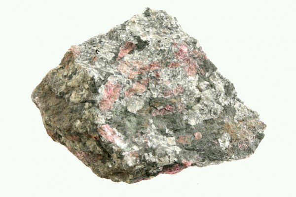 Eudialit - kamień naturalny, surowy, nieszlifowany. Szara skała z różowymi minerałami na jasnym tle.