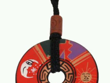 Okrągły wisiorek z kolorowym wzorem, przedstawiający słońce i księżyc, zawieszony na czarnym sznurku.