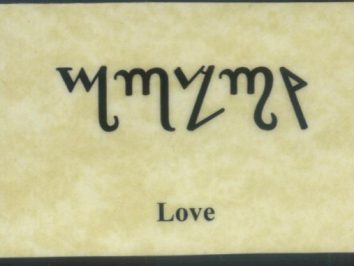 Napis „Love” w starożytnym alfabecie na jasnym tle, poniżej tłumaczenie po angielsku.