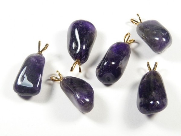 Sześć fioletowych kamieni z zawieszkami do wykonania biżuterii, leżących na białym tle.
