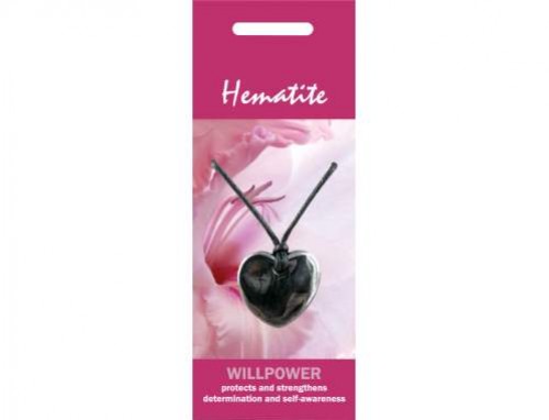 Naszyjnik z hematytu w kształcie serca, zawieszony na czarnym sznurku, na tle różowego opakowania.