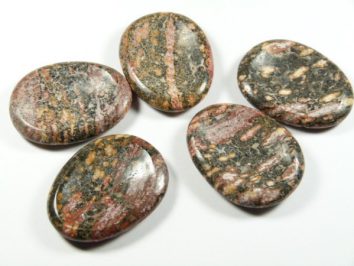 Jaspis skóra leoparda szlifowany płaski kamień. Pięć polerowanych kamieni o marmurkowym wzorze leży na białym tle.