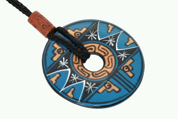 Niebieski wisiorek z etnicznymi wzorami, okrągły, zawieszony na czarnym sznurku.