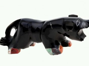 Czarna figurka niedźwiedzia z kolorowymi łapami, rzeźbiona z kamienia.