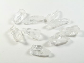 Dziewięć przezroczystych kryształków na białym tle.