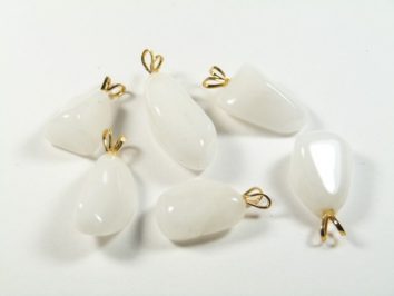 Sześć białych wisiorków z kamieni z metalowymi uchwytami leży na białym tle.