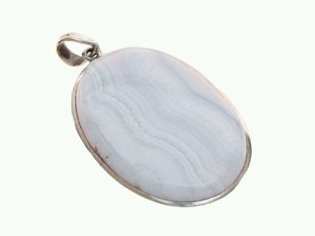 Owalny wisiorek z błękitnym kamieniem osadzony w srebrnej oprawie na jasnym tle.