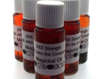 Pięć butelek olejku magicznego z etykietą “John the Conqueror” i białymi zakrętkami.