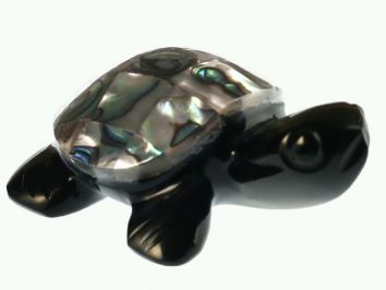 Czarna figurka żółwia z muszlą pokrytą kolorową masą perłową, na białym tle.