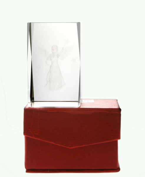 Szklana statuetka z wygrawerowanym aniołem stoi na czerwonym pudełku.