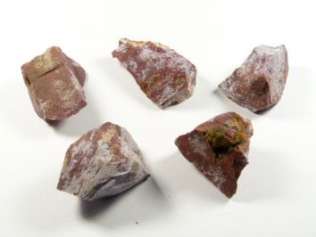 Jaspis ocean/ jaspis oceaniczny - kamień naturalny, surowy, nieszlifowany. Pięć surowych kawałków brązowego minerału leży na białym tle.