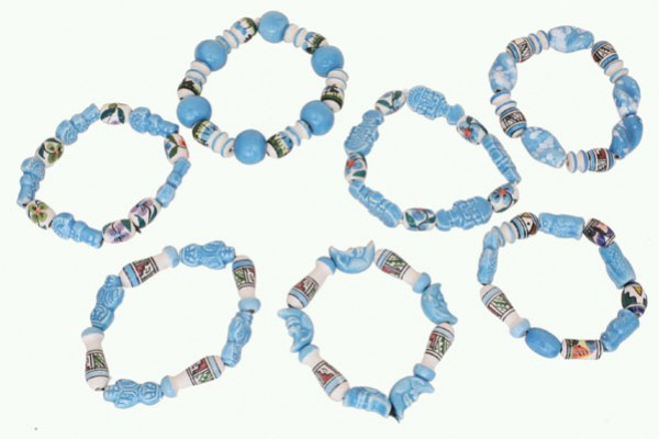 Siedem niebieskich bransoletek z koralików ułożonych w okrąg na jasnym tle.