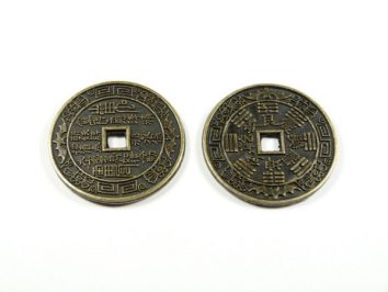 Dwa chińskie monety z kwadratowym otworem pośrodku, leżące na białym tle.