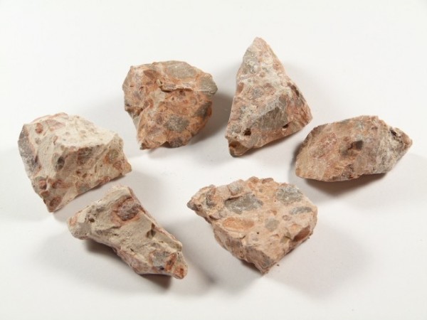 Sześć kawałków brązowego kamienia leży na białym tle.