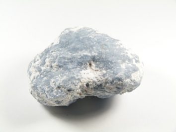 Jasnoniebieski kamień z białymi przebarwieniami na białym tle.